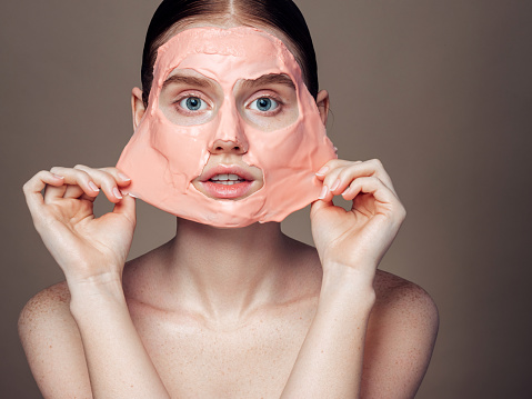 Beautiful young woman taking off moisturizing gel