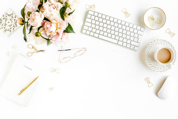 istock Flat lay women's office desk. Female workspace with computer, pink peonies bouquet, accessories on white background. Top view feminine background 1272477190