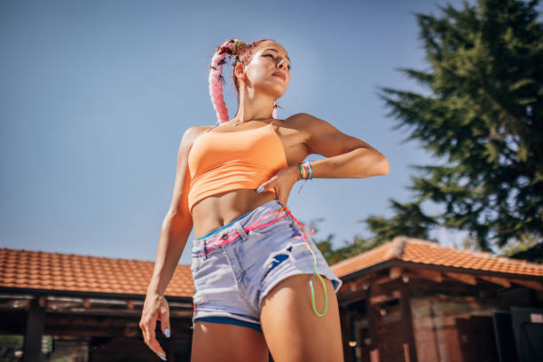Attractive young woman, modern dancer, posing outdoors on a sunny summer day.