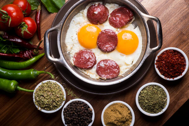 Fried sausage with egg in copper pan turkish meal