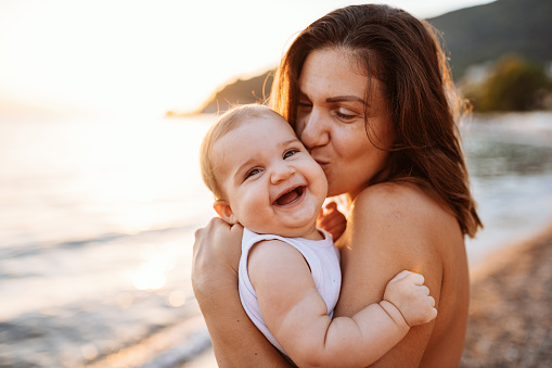 Mother holding baby at the beach