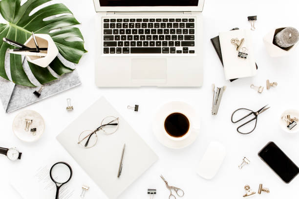 istock Home office workspace mockup with laptop, tropical leaves Monstera, clipboard, notebook and accessories on white background. Flat lay, top view 1272479532