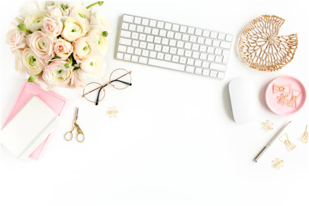 istock Stylized women's home office desk. Workspace with computer, bouquet ranunculus and roses, clipboard on white background. Flat lay. Top view 1272479673