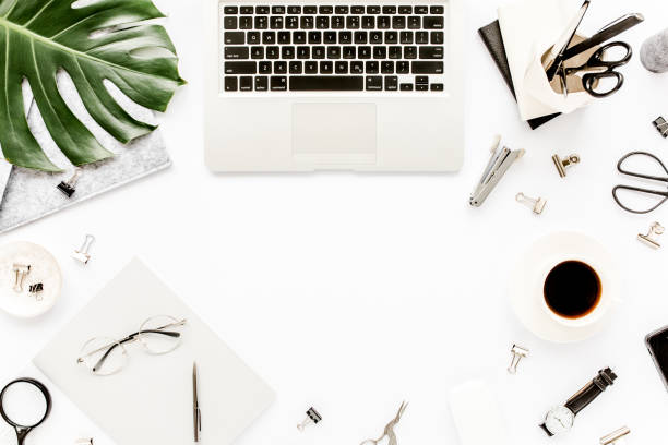 istock Home office workspace mockup with laptop, tropical leaves Monstera, clipboard, notebook and accessories on white background. Flat lay, top view 1272479889