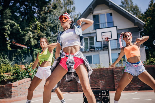 istock Three attractive young female dancers dancing outdoors on a sunny summer day 1272480659