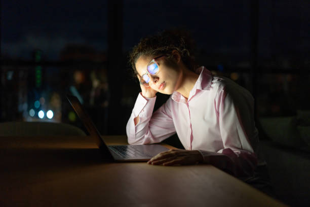 Tired business woman falling asleep while working late at the office