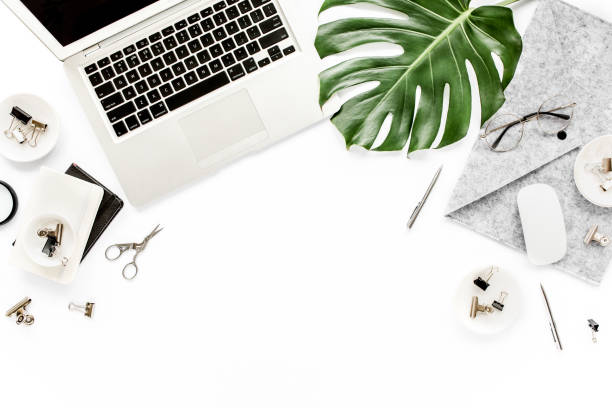 istock Home office workspace mockup with laptop, tropical leaves Monstera, clipboard, notebook and accessories on white background. Flat lay, top view 1272482236