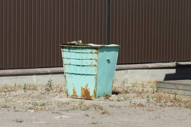 istock one old green iron trash can in rust stands on gray asphalt 1272482659