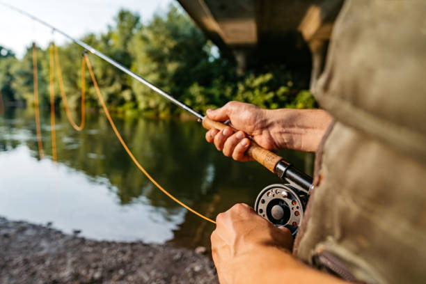 istock Man with a spinning fishing on the river 1272483956
