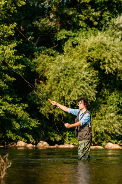 istock Fisherman fishing in a forest river 1272484559