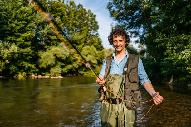 istock Fisherman fishing in a forest river 1272484730