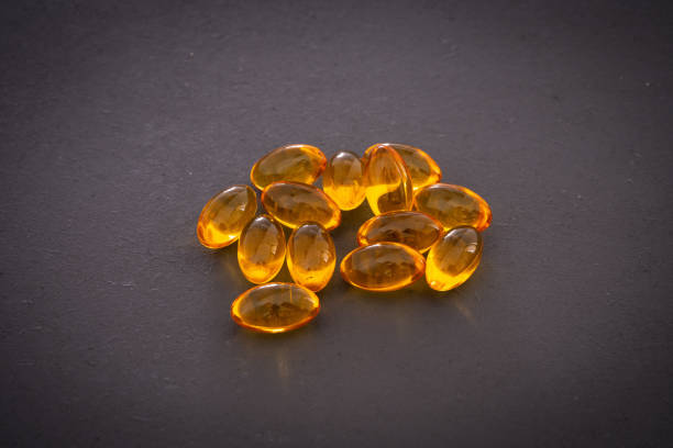 kapsułki omega 3 na czarnym tle - capsule pill lecithin fish oil zdjęcia i obrazy z banku zdjęć