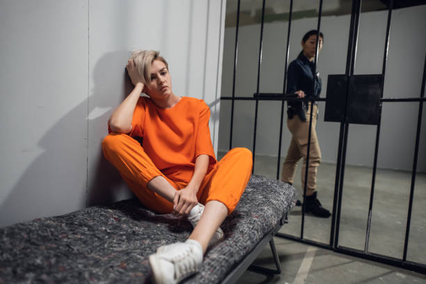 A young pretty blonde prisoner in a general regime prison is sitting in a solitary cell A young pretty blonde prisoner in a general regime prison is sitting in a solitary cell. child arrest stock pictures, royalty-free photos & images