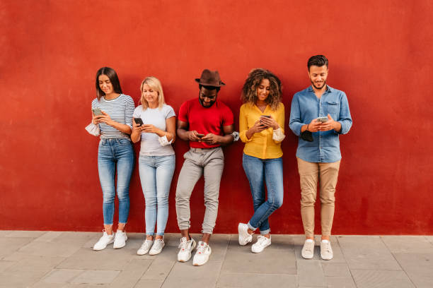 istock Five young people using phones next to each other 1272487267