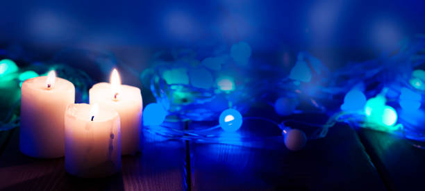 istock Candles on the blue night background with garland 1272488442