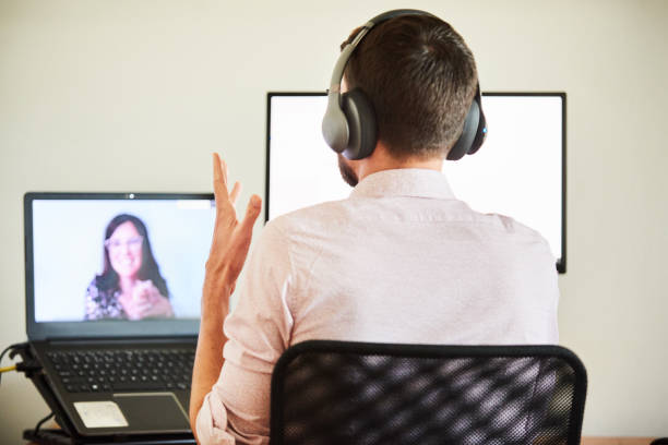istock Man video talking with a colleague while working remotely from home 1272490252
