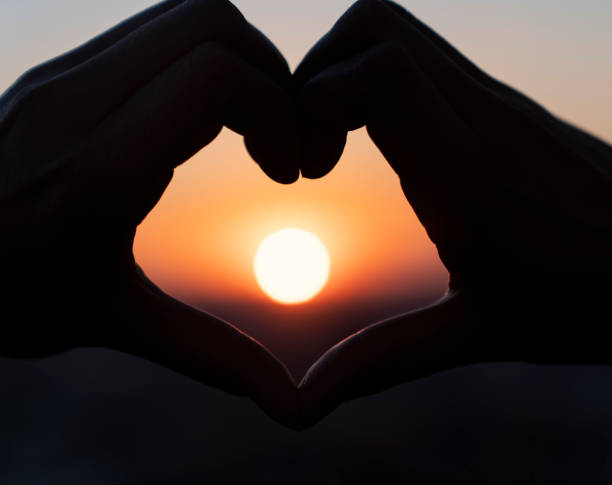 istock hands forming a heart shape with sunset silhouette 1272491143