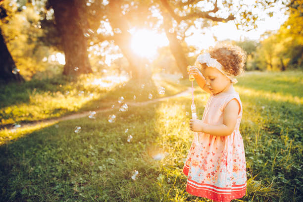 istock Child blowing soap bubbles outdoors 1272491547