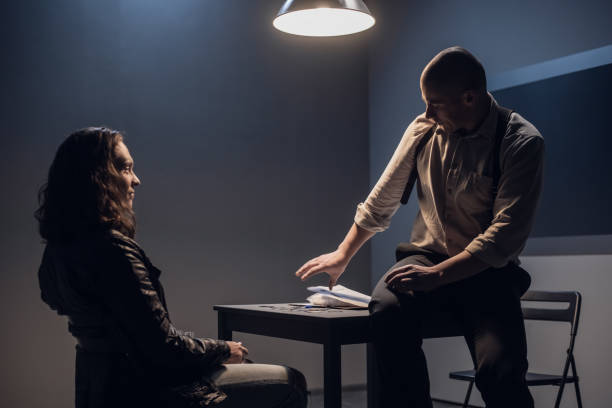 istock An experienced investigator sits on a table and reaches for documents to hand them over to the suspect for signature 1272492637