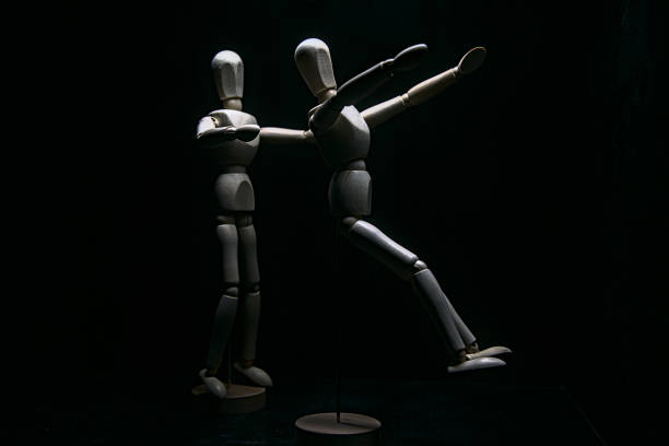 istock A wooden mannequin that is about to grab a falling one 1272492943