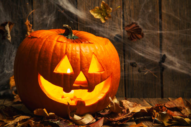istock Halloween Jack-o-Lantern Pumpkins on rustic wooden background 1272494606