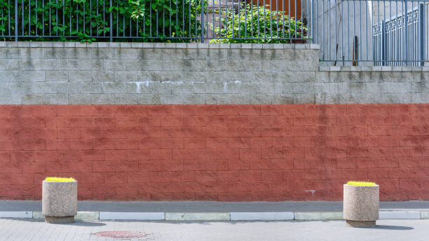 istock gray and red brick wall facade over tile sidewalk with flowerpots 1272494746