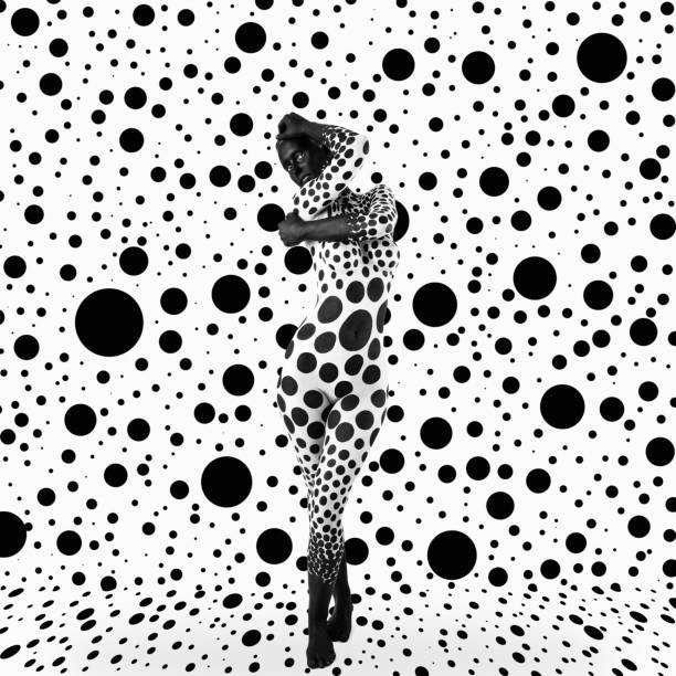 Bodypainting - black circles A woman with patterned bodypainting posing on a background filled with black circles weird spot stock pictures, royalty-free photos & images