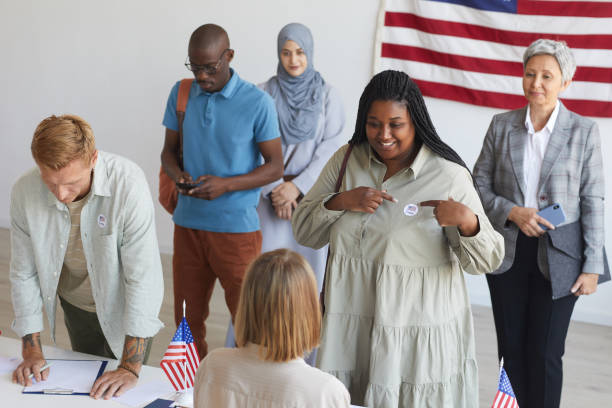istock Smiling People Registering at Voting Station 1272497358