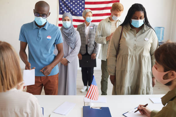 voters wearing masks at polling station - voting usa button politics imagens e fotografias de stock