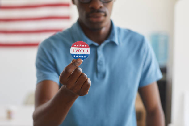 istock African-American Man Holding I VOTED Sticker 1272497411