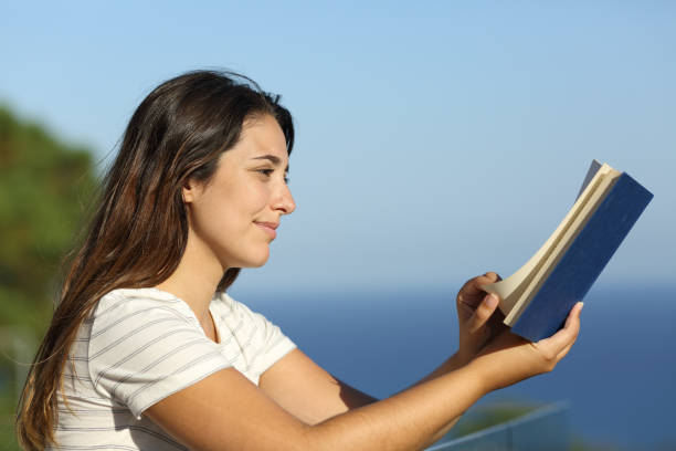istock Woman reading a book in a hotel balcony 1272498251