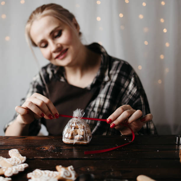 istock Woman packing Christmas gingerbread cookies 1272499791
