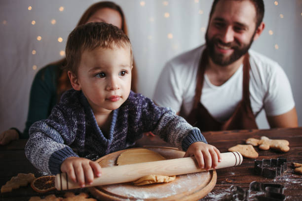 istock Mother, father and son kneading gingerbread dough 1272499854