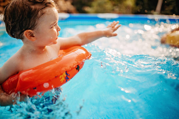 istock Boy playing in water with inflatable ring 1272500838