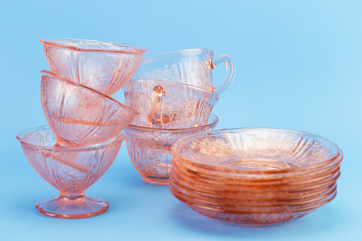 Pink depression glass coffee cups, saucers and ice cream bowls.