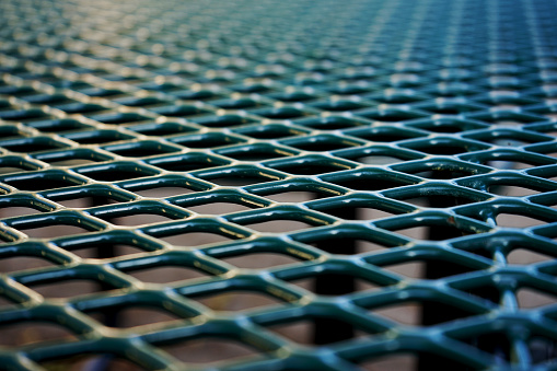 A green metal picnic table in closeup