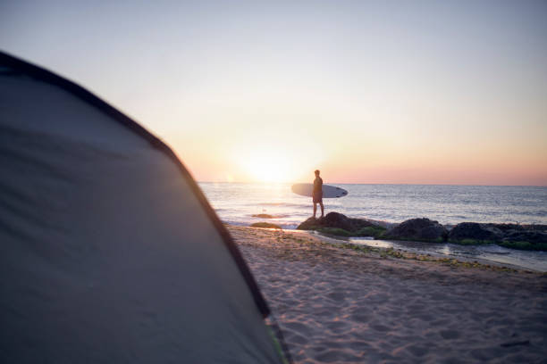 istock Male Surfer On The Beach At Sunrise. 1272506345