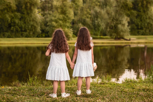 istock Anonymous sisters standing near pond 1272506771