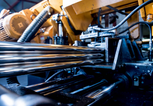 istock Automatic band saw machine with water coolant cutting metal pipes. 1272507812