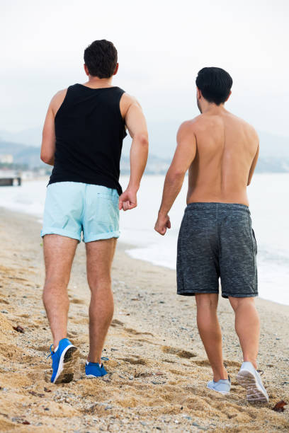istock Two sportsmen jogging on beach 1272507959