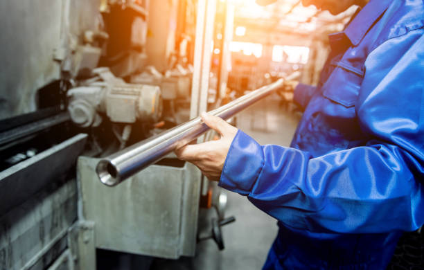Worker checking metal pipes at a metallurgical plant