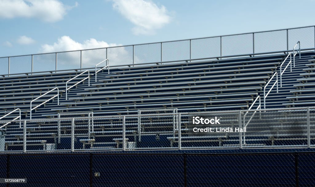 Empty Sports Stadium Due to Pandemic Empty benches in sports stadium.  Represents lockdown in sports due to coronavirus. Soccer Stock Photo