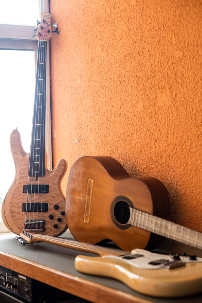istock Guitars of different kind hanging and lying at young musician's studio 1272510015