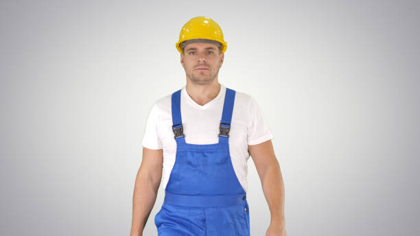 istock Walking worker in yellow helmet on gradient background 1272510797