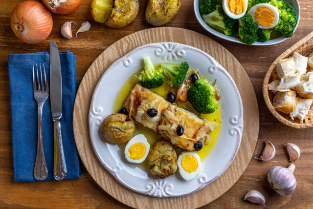 istock Cod loin baked in olive oil, with potatoes, broccoli, boiled egg and black olives. Typical dish of Portugal. Top view. 1272522389