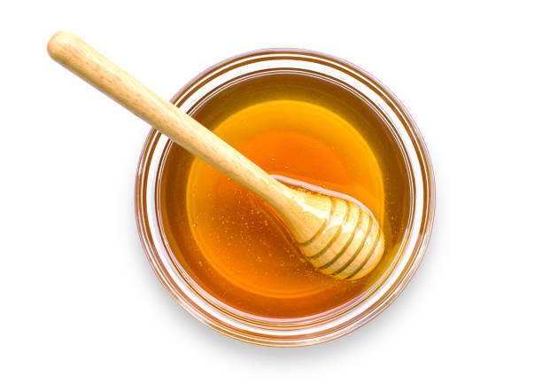 mel dourado com favo de mel de madeira em tigela de vidro isolado em branco - breakfast stick honey meal - fotografias e filmes do acervo