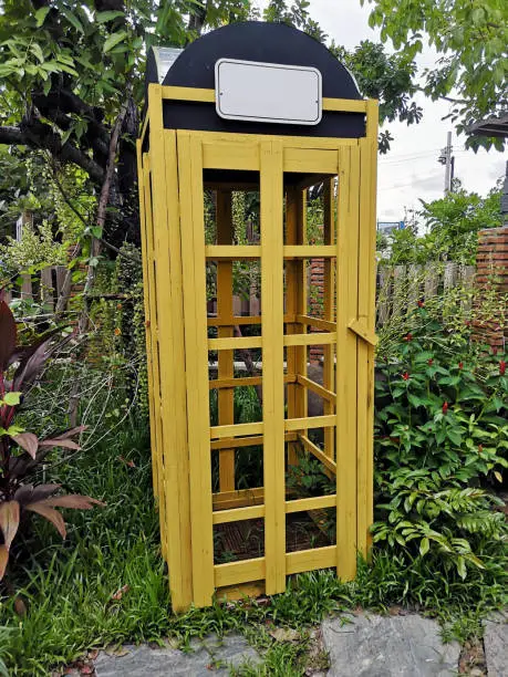 Photo of The garden decorating using a yellow wood phone booth. english style