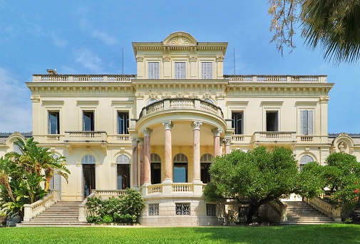 Cannes, France - August 2020 - The villa Rothschild is a villa built in neoclassical style from 1881. Now the building serves as a public library and the botanical garden is accessible to the public. Sunny day with blue sky.