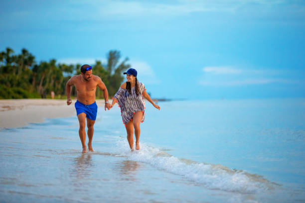 istock Hispanic couple running on the beach 1272533551