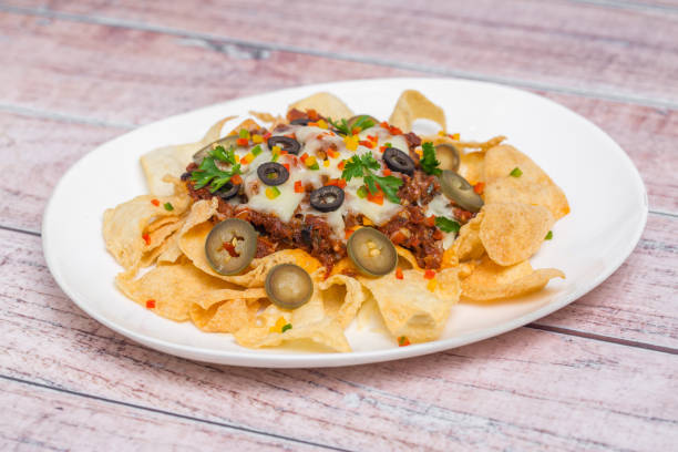 comida mexicana famosa carne moída picante nachos. chips de tortilla crocante aquecidos com queijo derretido e jalapeno servido um lanche. - chili pepper guacamole food beer - fotografias e filmes do acervo